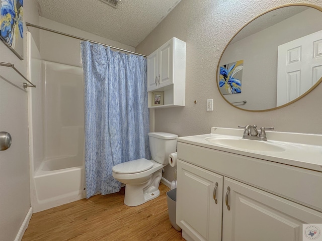 full bathroom featuring toilet, shower / tub combo with curtain, a textured ceiling, wood-type flooring, and vanity