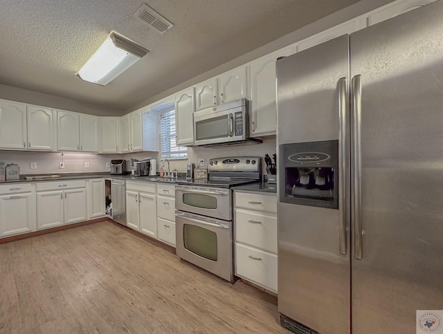 kitchen featuring white cabinets, light hardwood / wood-style floors, appliances with stainless steel finishes, and sink