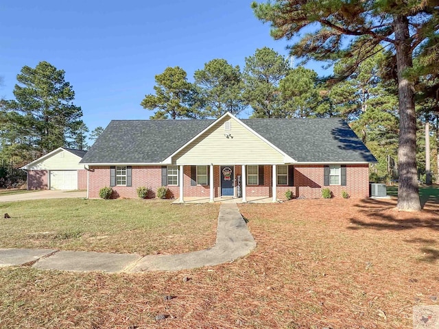 view of front of house featuring a porch, a front yard, central AC, and a garage