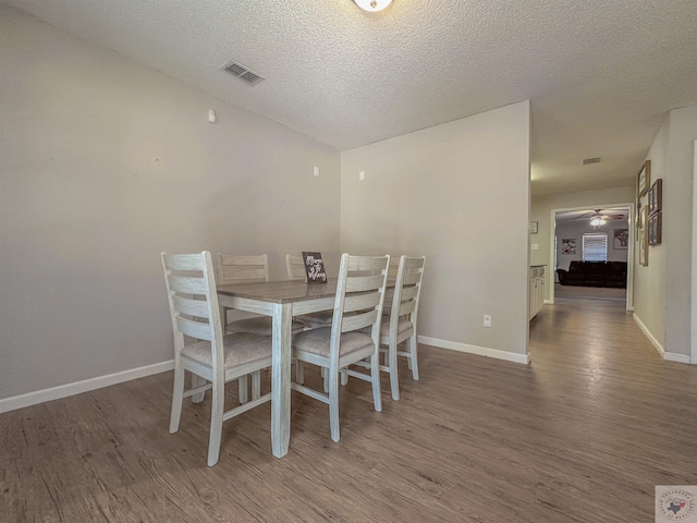 dining room with hardwood / wood-style flooring, a textured ceiling, and ceiling fan