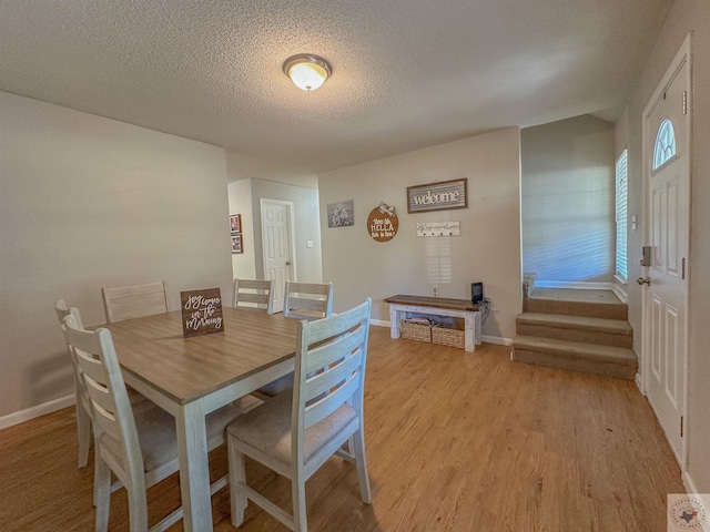 dining room featuring light hardwood / wood-style flooring and a textured ceiling