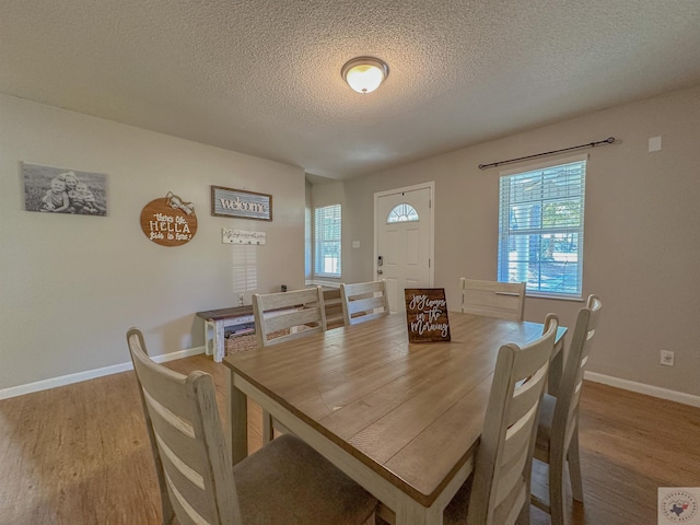 dining room with hardwood / wood-style flooring and a textured ceiling