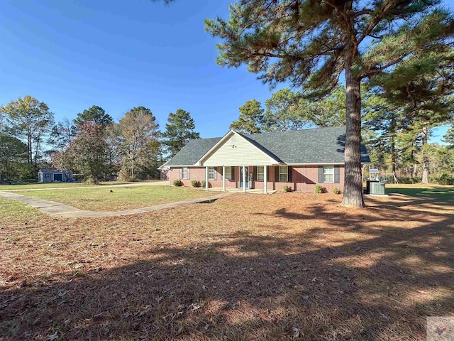 view of front of home with covered porch, central air condition unit, and a front yard