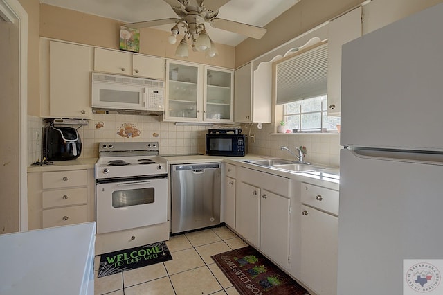 kitchen with white appliances, white cabinets, sink, ceiling fan, and light tile patterned floors