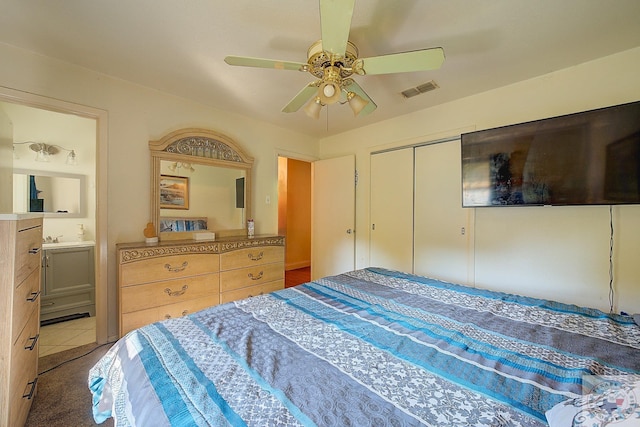 tiled bedroom featuring ceiling fan, connected bathroom, and a closet