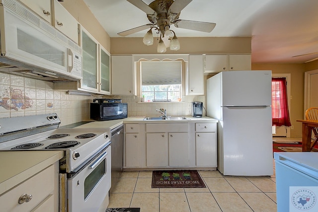 kitchen with sink, white appliances, white cabinets, and light tile patterned floors