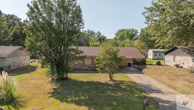 view of front of house featuring central air condition unit, a carport, and a front lawn