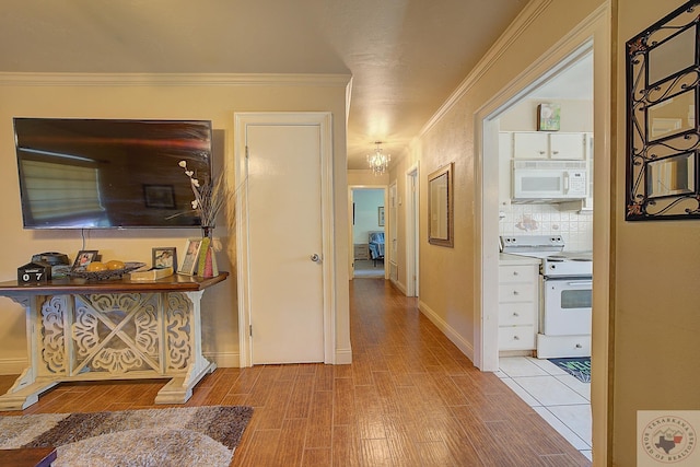 hallway with light hardwood / wood-style flooring and ornamental molding