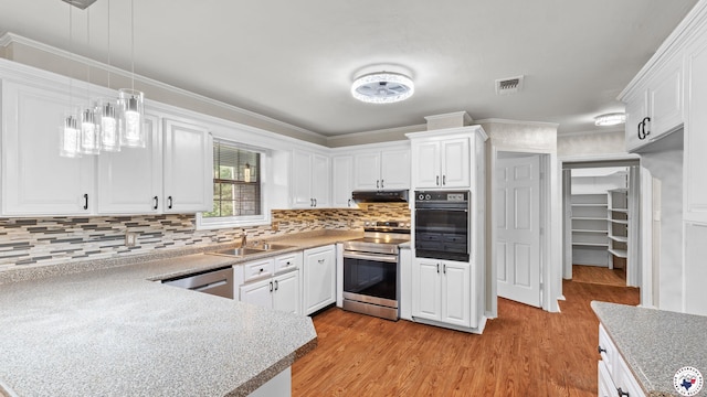 1599 Myrtle Springs Rd, Texarkana, TX 75503 - kitchen with stainless steel appliances, under cabinet range hood, a sink, white cabinets, and ornamental molding