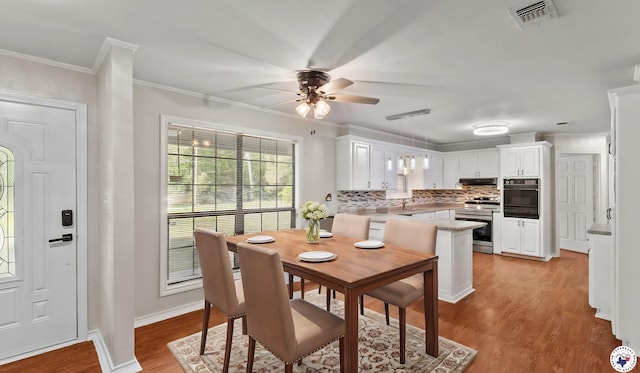 1599 Myrtle Springs Rd, Texarkana, TX 75503 - dining area featuring ceiling fan, light wood-style flooring, crown molding, and baseboards