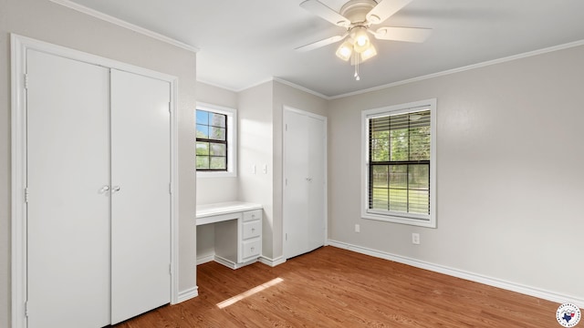 1599 Myrtle Springs Rd, Texarkana, TX 75503 - unfurnished bedroom with light wood-type flooring, multiple windows, multiple closets, baseboards, and crown molding