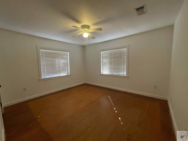 unfurnished room featuring dark wood-type flooring and ceiling fan