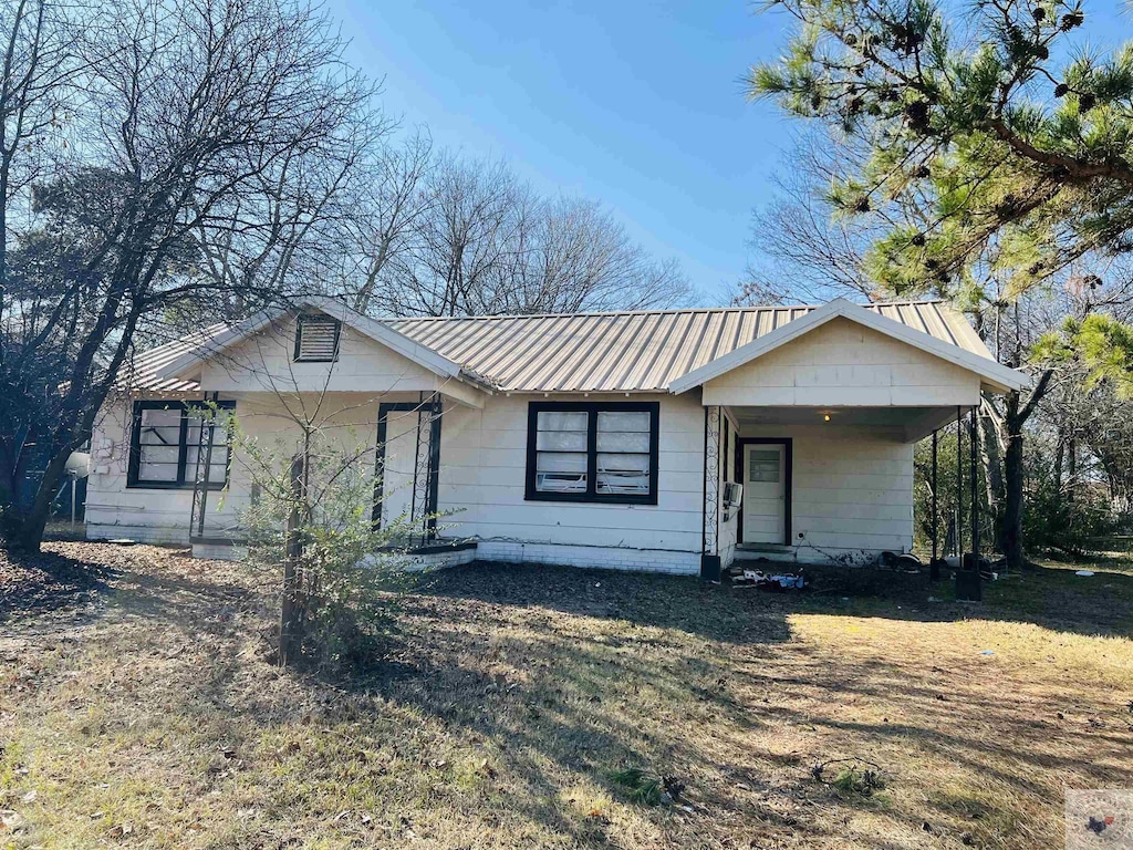 view of front of house with a front lawn and a carport