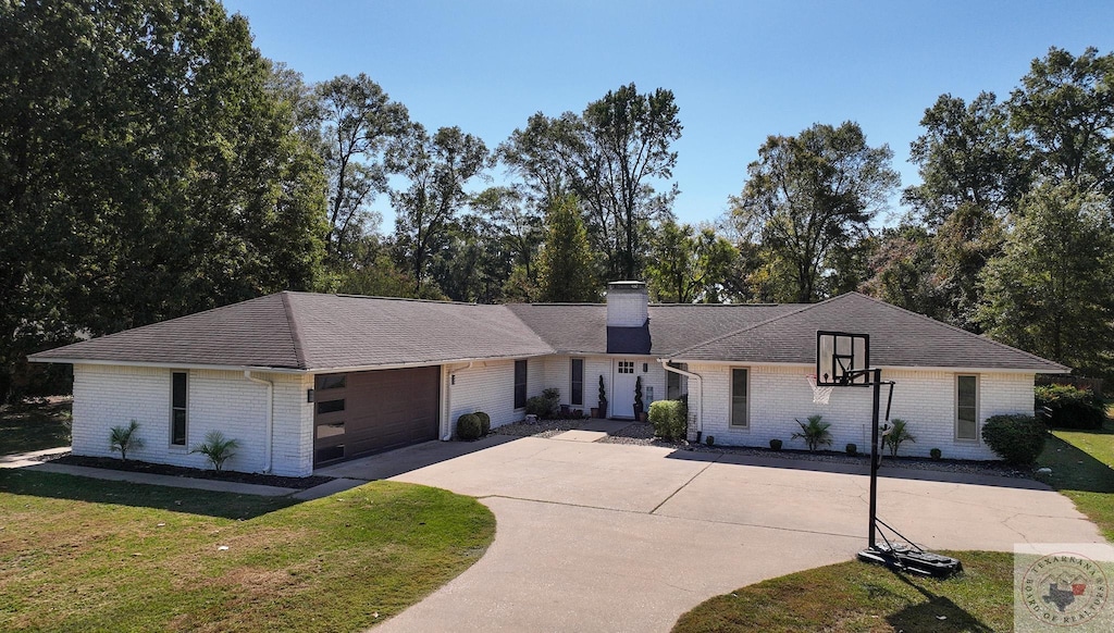 ranch-style home with a garage and a front lawn