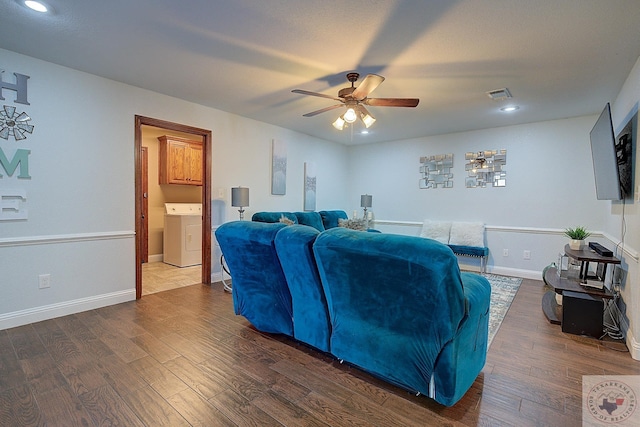 living room featuring washer / clothes dryer, dark wood-type flooring, and ceiling fan