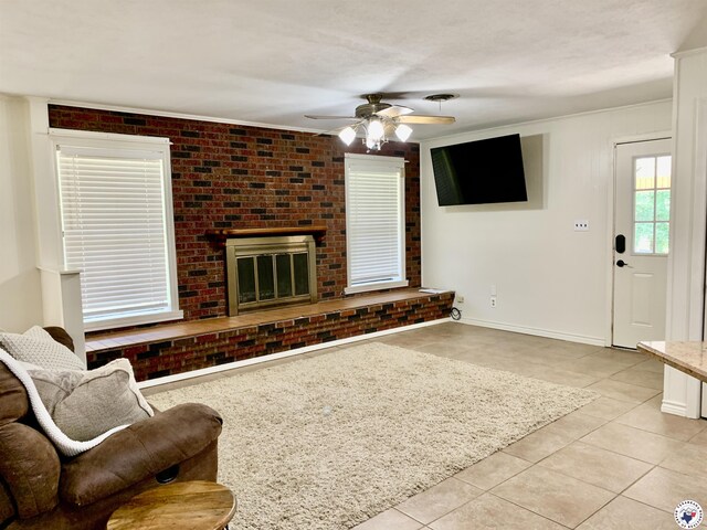 308 Eleanor St, Atlanta, TX 75551 - living area with light tile patterned flooring, a ceiling fan, a fireplace, ornamental molding, and brick wall