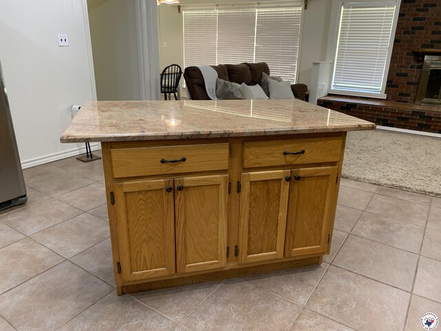 308 Eleanor St, Atlanta, TX 75551 - kitchen featuring open floor plan, light tile patterned floors, light stone counters, and a kitchen island