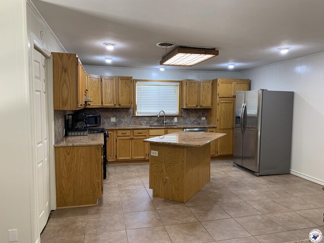 308 Eleanor St, Atlanta, TX 75551 - kitchen featuring appliances with stainless steel finishes, decorative backsplash, light stone countertops, and a kitchen island