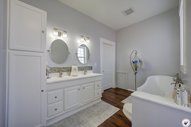 501 Main St, Texarkana, TX 75501 - bathroom with a freestanding tub, wood finished floors, visible vents, and a sink