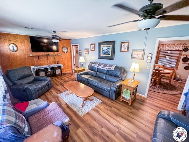 1004 Hillcrest St, Linden, TX 75563 - living room featuring a ceiling fan, wood finished floors, wooden walls, baseboards, and ornamental molding