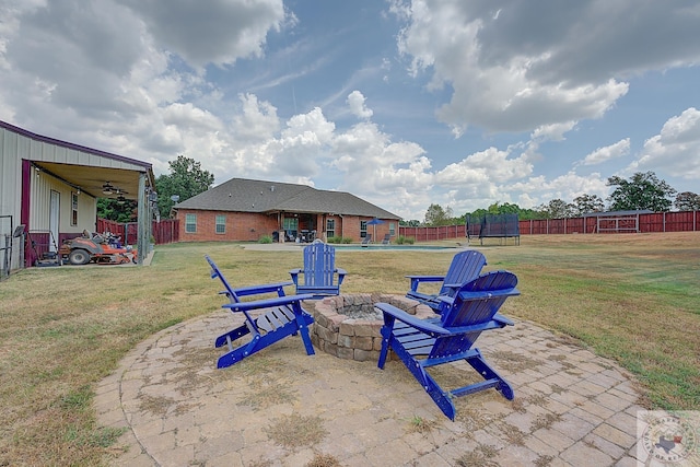 view of patio / terrace featuring an outdoor fire pit and a trampoline