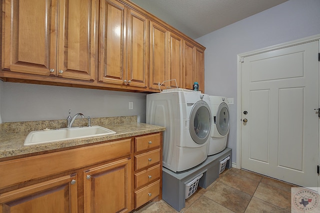 clothes washing area featuring cabinets, washing machine and dryer, sink, and light tile patterned flooring