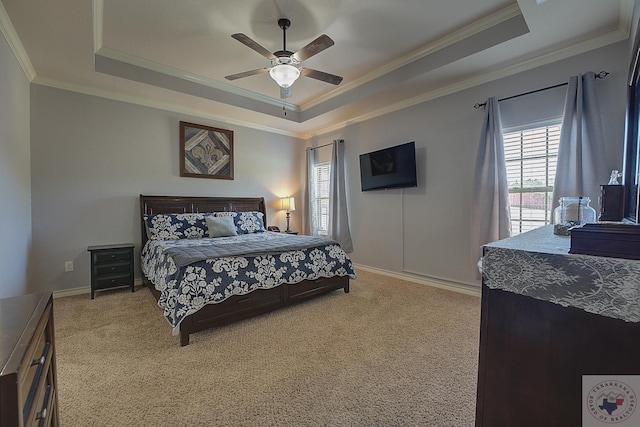 bedroom with ceiling fan, light colored carpet, a tray ceiling, and ornamental molding