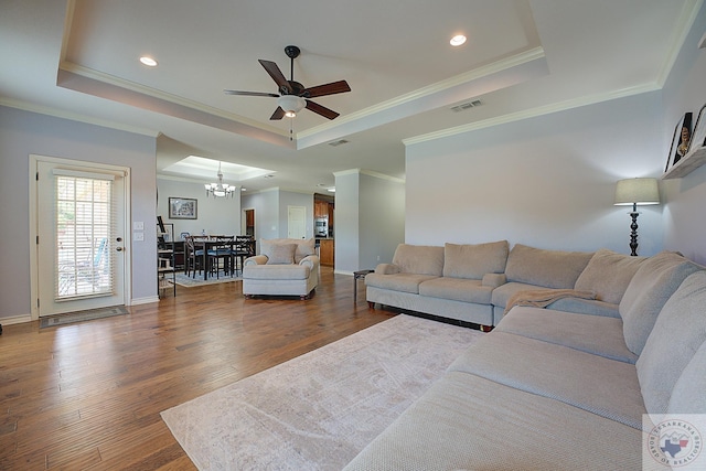 living room with dark hardwood / wood-style floors and a raised ceiling