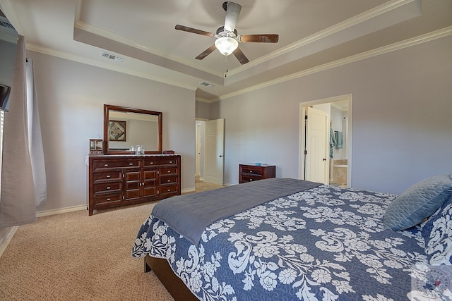 carpeted bedroom featuring ornamental molding, ensuite bath, ceiling fan, and a tray ceiling