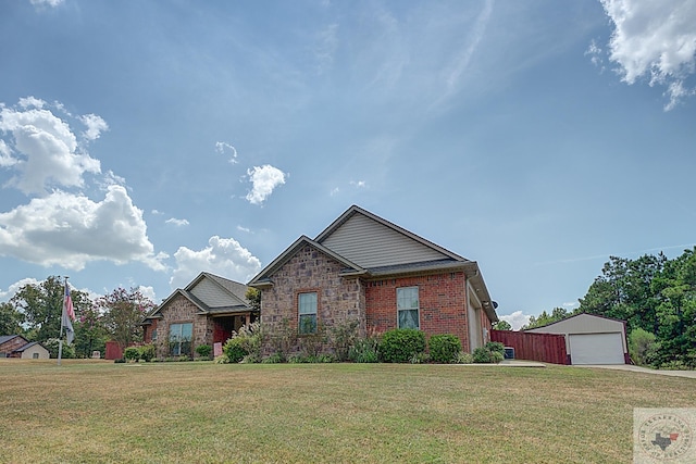 view of front of home with a garage, an outdoor structure, and a front yard