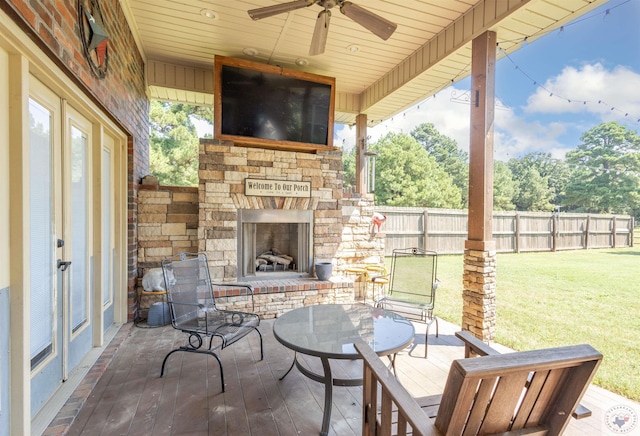 view of patio with ceiling fan and an outdoor stone fireplace