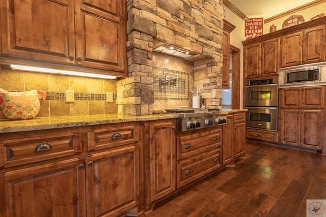 kitchen featuring tasteful backsplash, ornamental molding, dark wood-type flooring, stainless steel appliances, and light stone counters