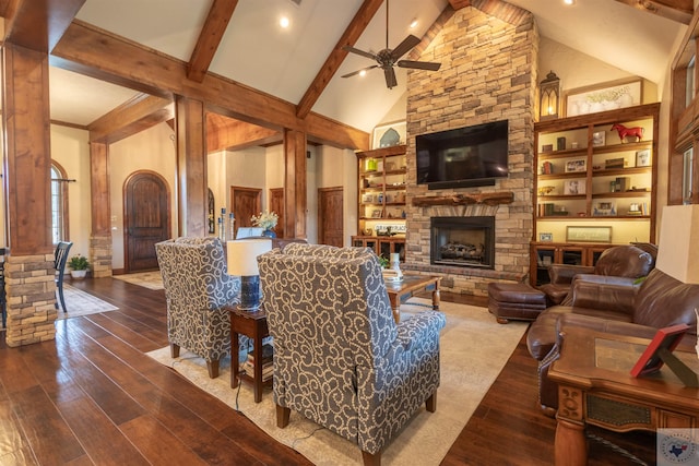 living room featuring wood-type flooring, a fireplace, ceiling fan, high vaulted ceiling, and beam ceiling