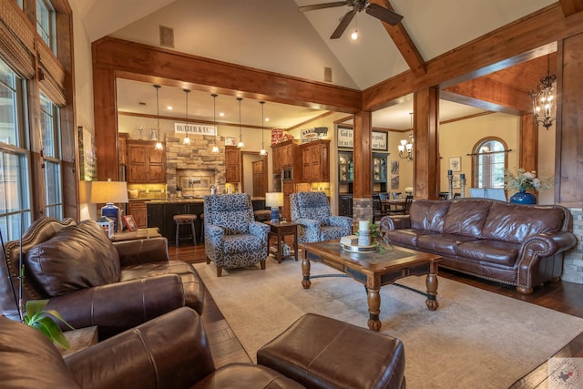 living room with beam ceiling, ceiling fan with notable chandelier, high vaulted ceiling, and hardwood / wood-style floors