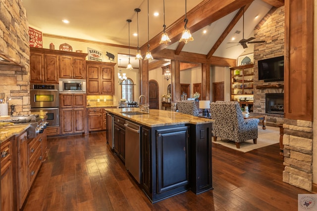 kitchen featuring pendant lighting, a large island, sink, beamed ceiling, and stainless steel appliances