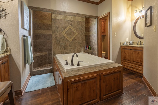 full bathroom featuring hardwood / wood-style floors, toilet, shower with separate bathtub, and vanity