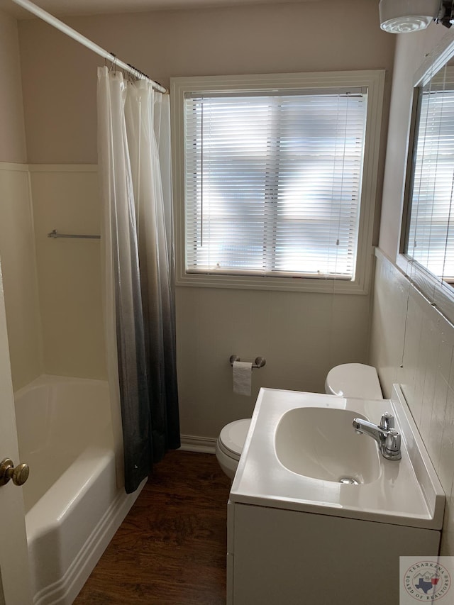 full bathroom with sink, hardwood / wood-style flooring, toilet, and shower / tub combo with curtain