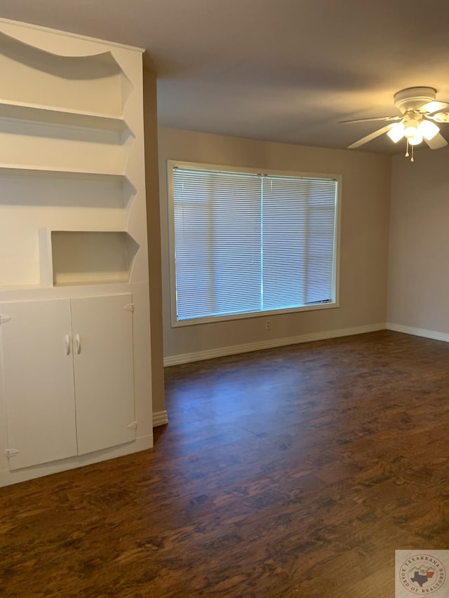 unfurnished room with ceiling fan and dark wood-type flooring