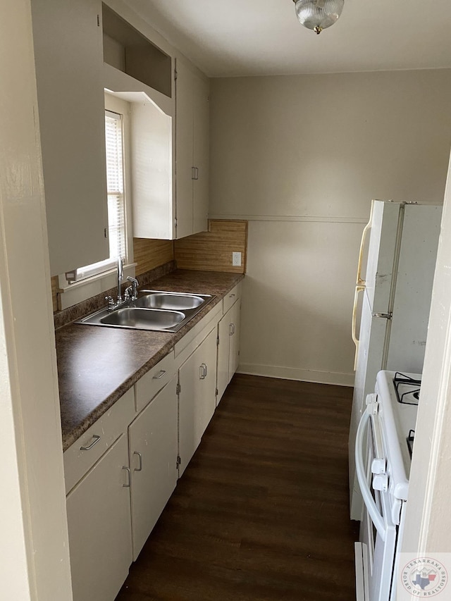 kitchen with white cabinets, white appliances, dark hardwood / wood-style flooring, and sink