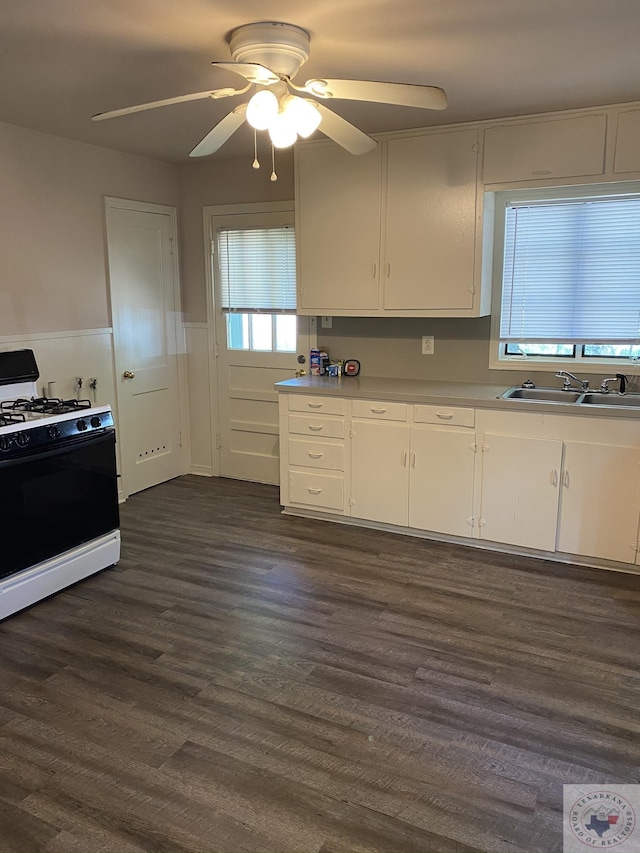 kitchen featuring sink, white cabinets, gas stove, ceiling fan, and dark hardwood / wood-style floors