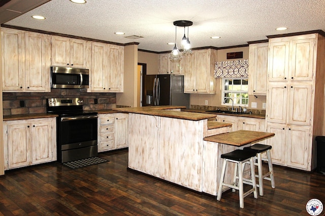 632 White Oak Rd, Maud, TX 75567 - kitchen with appliances with stainless steel finishes, butcher block countertops, a kitchen island, a textured ceiling, and dark wood-style floors