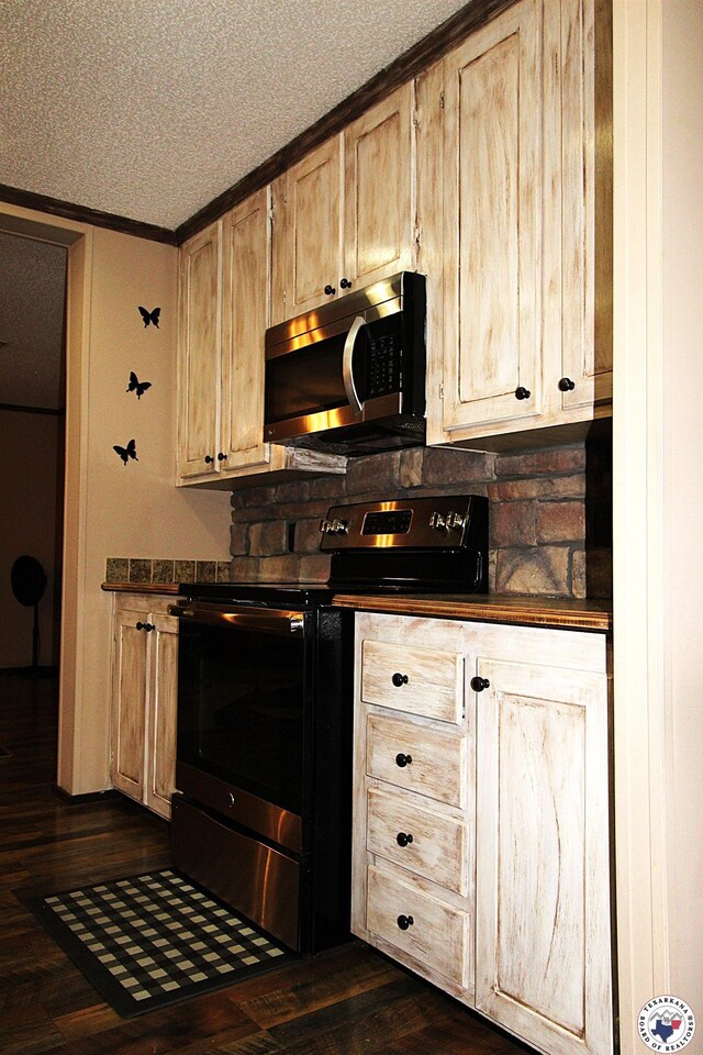 632 White Oak Rd, Maud, TX 75567 - kitchen with stainless steel microwave, range with electric cooktop, dark countertops, a textured ceiling, and ornamental molding