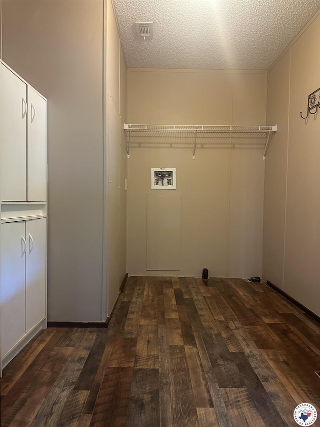 632 White Oak Rd, Maud, TX 75567 - laundry room featuring cabinet space, hookup for a washing machine, a textured ceiling, and wood finished floors