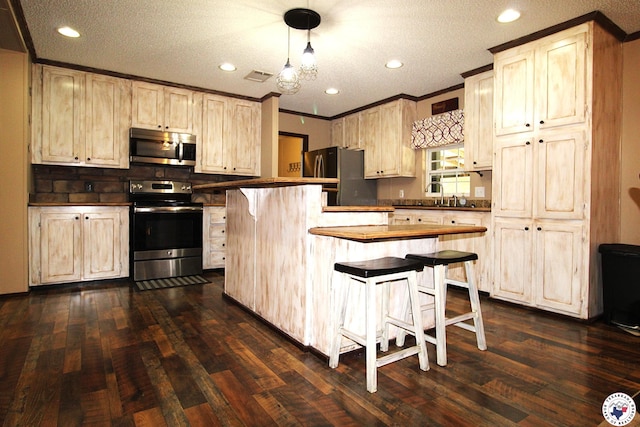 632 White Oak Rd, Maud, TX 75567 - kitchen with stainless steel appliances, crown molding, dark wood-style flooring, recessed lighting, and a breakfast bar area