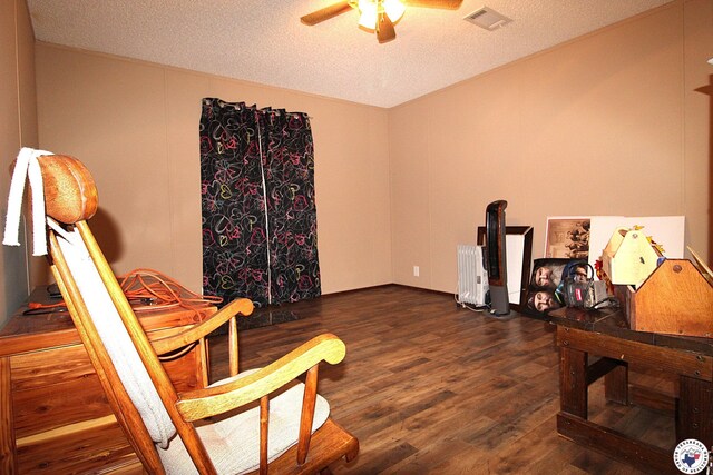 632 White Oak Rd, Maud, TX 75567 - sitting room with wood finished floors, ceiling fan, a textured ceiling, and radiator heating unit