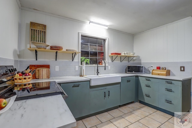 kitchen with sink, decorative backsplash, light tile patterned floors, and stainless steel appliances