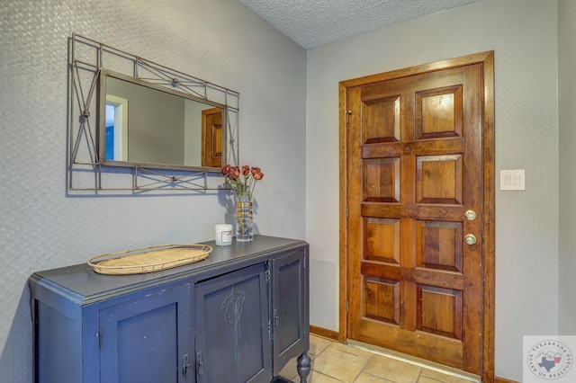 tiled entrance foyer featuring a textured ceiling