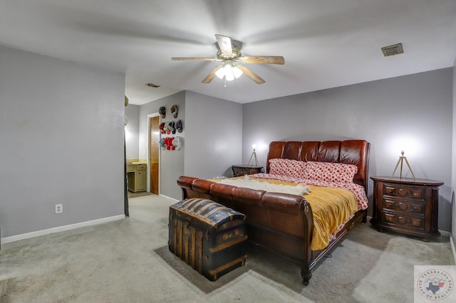 carpeted bedroom with ensuite bathroom and ceiling fan