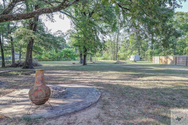 view of yard featuring an outdoor fire pit and a storage shed