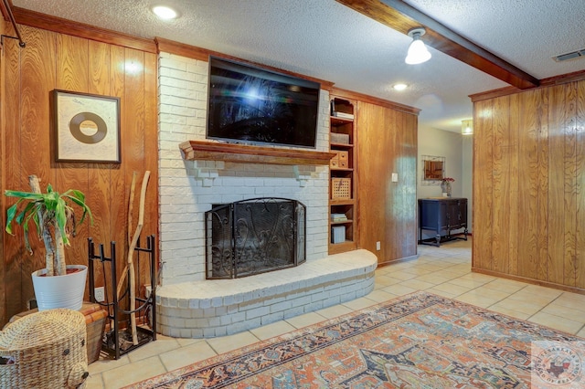 tiled living room with beam ceiling, a fireplace, built in shelves, a textured ceiling, and wood walls